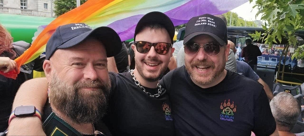 Rob, Oran and me in front of a rainbow flag.